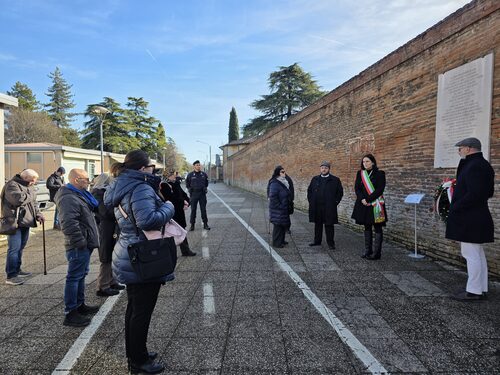 Persone che rendono omaggio alla lapide dedicata agli zingari deportati
